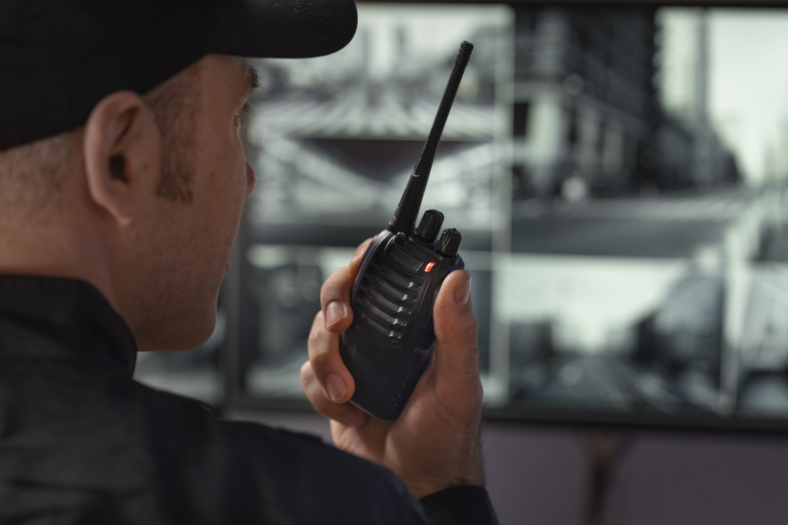Security professional monitoring surveillance cameras with a radio